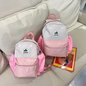 Detail view of pink and grey contrast kids backpack on a sofa with storybooks