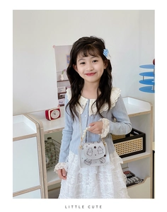 Detail of child wearing a gray crossbody bag with pearl handle and lace outfit