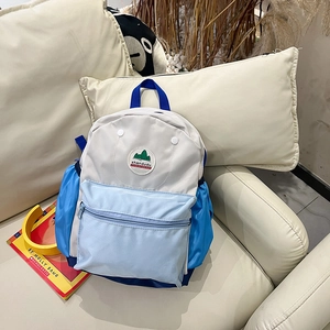 Close-up of kids backpack featuring blue and white panels with durable zippers and side pockets
