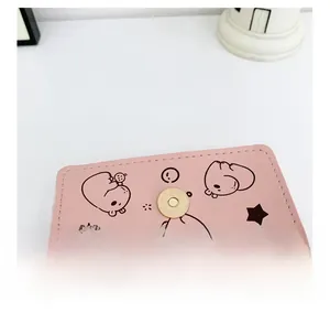 Detail of pink PU leather mini bag featuring cute cartoon bear print and gold magnetic clasp