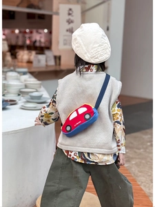 Kid's car-shaped crossbody bag featuring red and blue colors worn by a young model