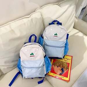Detail of color-block kids backpack with nylon texture and front zipper pocket