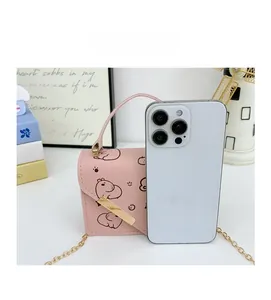 Pink mini crossbody bag size comparison with iPhone featuring cartoon hippo print