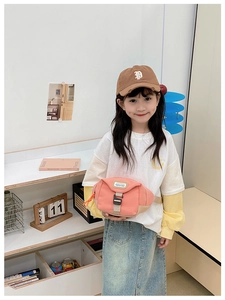 Sac banane enfant en toile rose et blanc avec boucle réglable porté par une fille