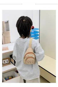 Detailed close-up of khaki nylon kids chest bag with letter print and adjustable strap