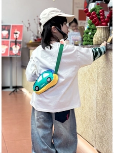 Rear view of a child wearing a colorful 3D car-shaped crossbody bag with adjustable strap
