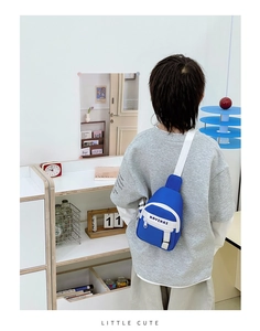 Close-up of blue kids chest bag with KAVINAI lettering and adjustable white strap