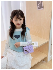 Detail shot of a purple cartoon character mini crossbody bag on a child's shoulder