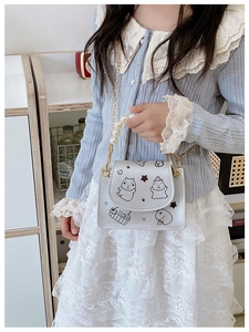 Detail view of mini silver crossbody bag with Capybara print and faux pearl handle
