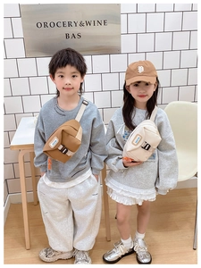 Détail des sacs bananes en toile pour enfants avec boucle portés par des modèles enfants