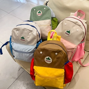 Detail of multi-color nylon kids backpacks with front zipper pockets and side mesh bags