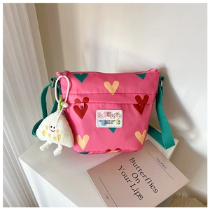 Détail du sac bandoulière en toile rose avec motif cœur et pendentif fantôme en peluche