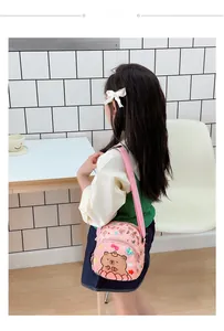 Pink round nylon crossbody bag for kids featuring a cute brown bear and flower print