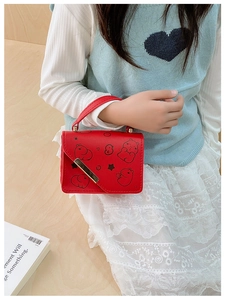 Detail of red cartoon capybara handbag with metal lock shown on light background