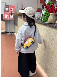 Detail of cute yellow car chest bag with adjustable strap worn by a young child