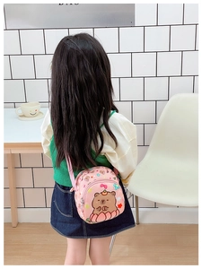 Rear view of a child wearing a pink cartoon bear crossbody bag with adjustable strap