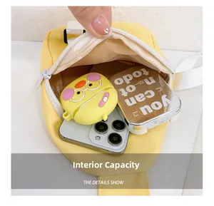 Detail view showing internal storage capacity for phone and earphones in yellow canvas bag