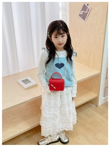 Close-up of a red cartoon print crossbody bag with gold chain and handle for kids