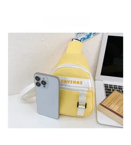 Detailed size comparison of yellow canvas mini chest bag next to a mobile phone