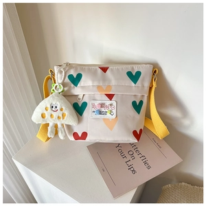 Détail de la sacoche en toile avec motifs de cœur et accessoire peluche mignon