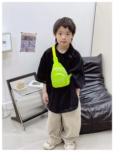 Detail view of fluorescent green canvas kids chest bag with white letter printing