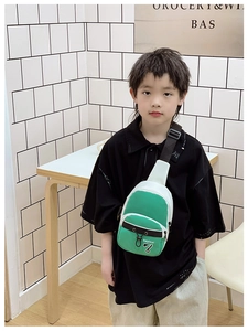Gros plan d'un enfant portant un sac de poitrine en toile bicolore vert et blanc tendance