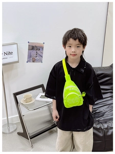 Detailed view of neon green kids chest bag featuring letter prints and durable wide straps