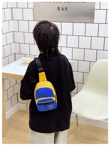 Détail d'un sac de poitrine enfant bleu et jaune avec bandoulière réglable en situation