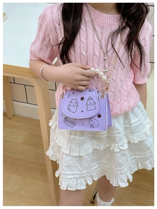 Detail of purple children's shoulder bag with cartoon capybara and pearl handle
