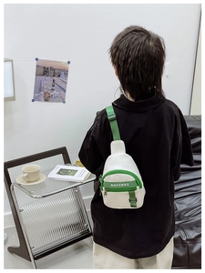 Detailed view of color-block kids chest bag with green zipper and adjustable strap