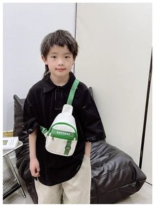 Detail of kids chest bag showing green zipper and white KAVINAI letter print