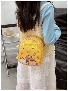 Detail shot of small yellow crossbody bag with cute animal prints and adjustable strap
