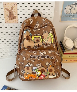Detail of cute brown capybara print backpack with embroidery and school supplies