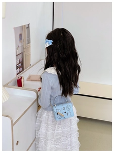 Rear view of a light blue cartoon bear print crossbody bag for girls with chain strap