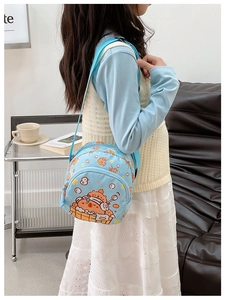 Detailed view of child wearing light blue nylon crossbody bag with cute animal print