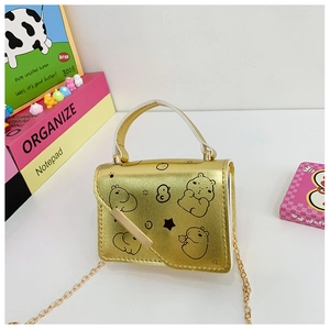 Close-up of golden mini crossbody bag with cartoon bear print and fine metal chain strap