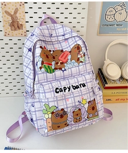 Detail of purple plaid backpack featuring cute capybara prints on a student desk setting