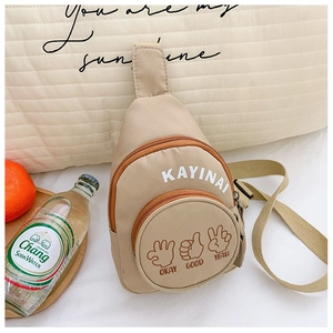 Detail of khaki kids chest bag with letter print and playful hand gesture illustrations