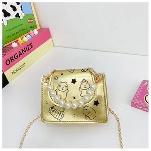 Detail of golden mini bag with capybara print, pearl handle, and metal chain strap