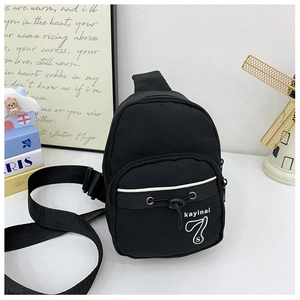 Détail du sac bandoulière noir en toile avec bandoulière réglable et logo imprimé