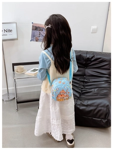 Detail of light blue mini backpack for kids featuring cute bear and breakfast patterns