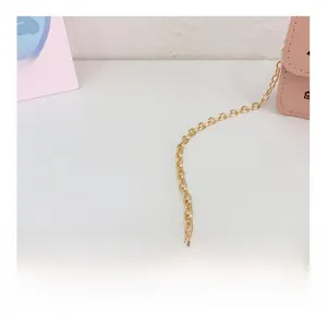 Dettaglio della tracolla a catena dorata e pelle rosa di una mini borsa da bambina