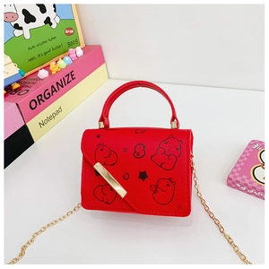 Detail of red cartoon kids handbag with gold chain strap and metal snap closure