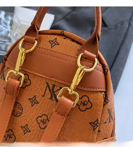 Close-up of brown pebbled leather backpack with floral monogram and gold metal hardware