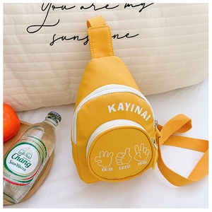 Detail of yellow nylon chest bag for kids featuring playful hand gestures and logo