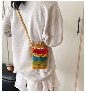 Détail du sac bandoulière monstre tricoté main avec visage drôle et fil de couleur