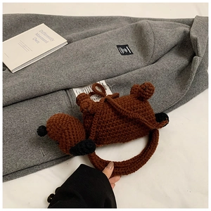 Detail showing handcrafted brown knitted puppy shoulder bag with soft crochet texture