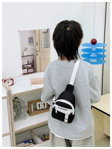 Rear view of kid wearing black and white contrast chest bag with adjustable strap