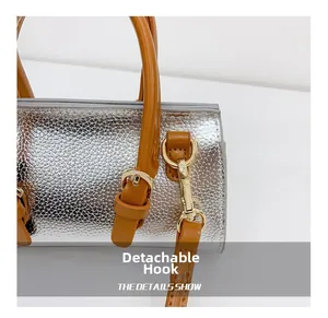 Close-up of detachable gold hook and silver textured leather on children's handbag