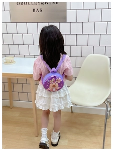 Toddler modeling a purple round Capybara hard shell backpack for outdoor use